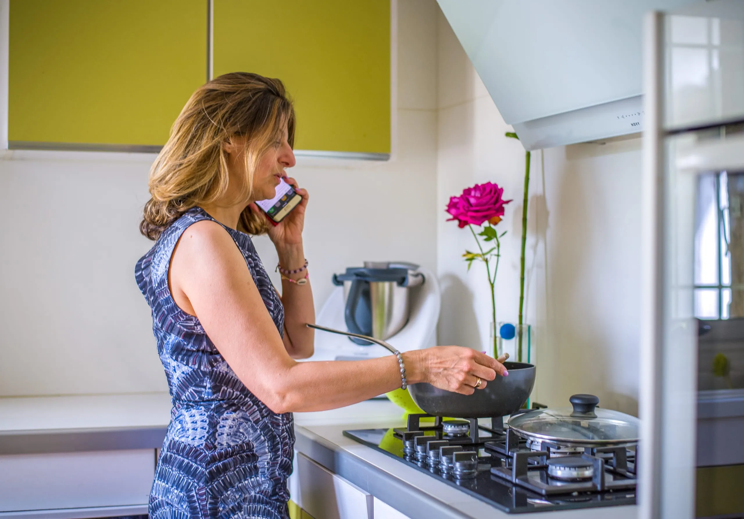 Gabrielle Ladevant, coach de vie à Toulouse, au téléphone dans sa cuisine tout en cuisinant.